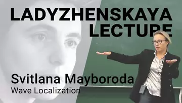 Svitlana Mayboroda gestikuliert während der Ladyzhenskaya Vorlesung 2023 daneben ein einfarbiges Porträt von Ladyzhenskaya.