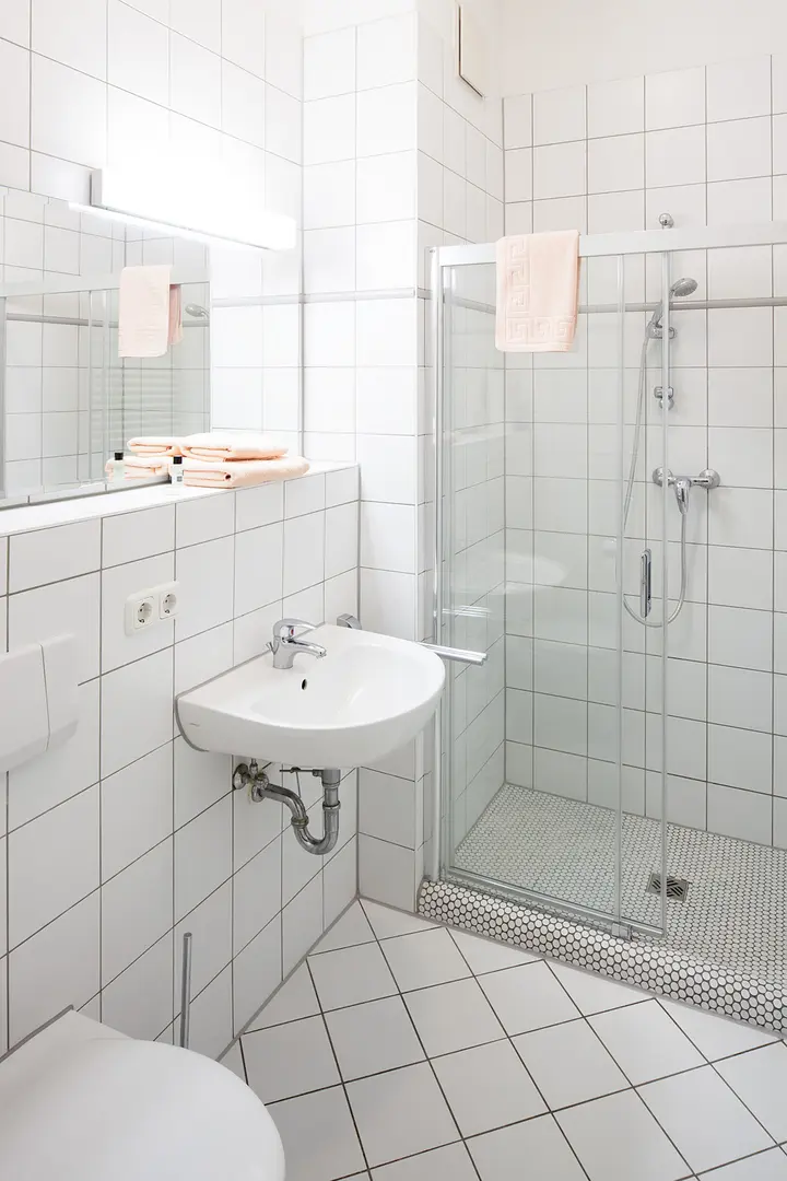 Badezimmer mit Dusche, Toilette und Waschbecken