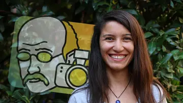 Portrait of Sefika Kuzgun outside in front of green plants and the Math Planck People logo