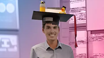 Portrait of Markus Tempelmayr, wearing a big selfmade PhD hat