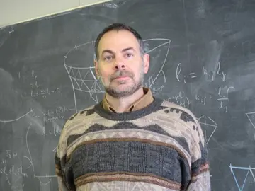 Portrait of Emil Saucan in front of a blackboard