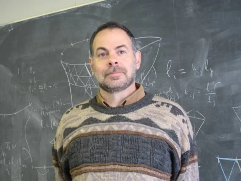Portrait of Emil Saucan in front of a blackboard