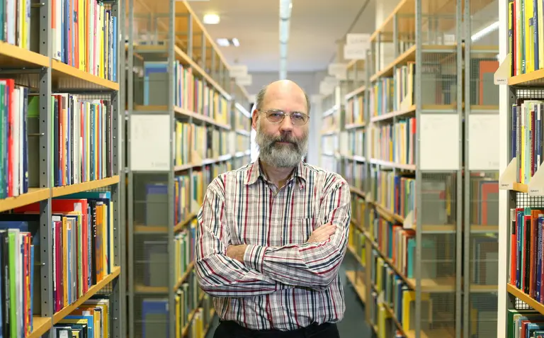 Portrait von Wolfgang Hackbusch in einer Bibliothek