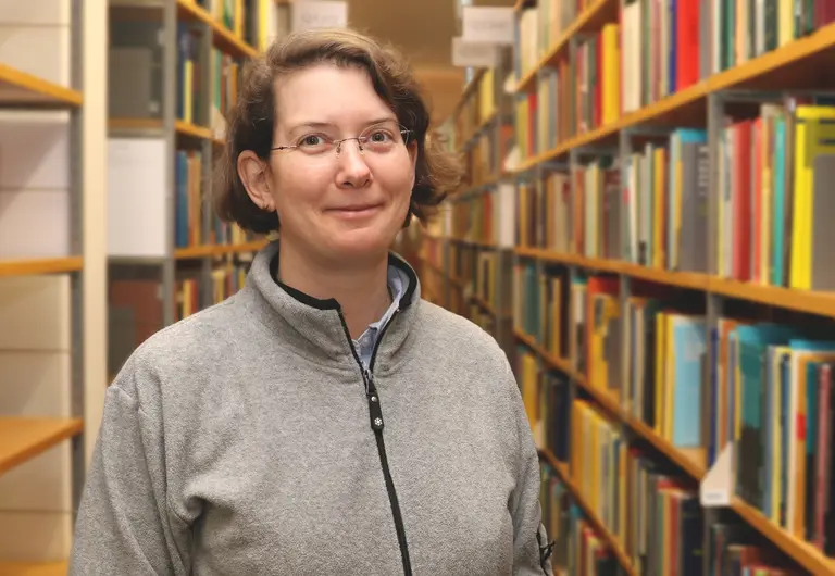 Portrait of Angkana Rüland in front of a bookshelf