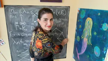 Portrait of Raffaella Mulas drawing a graph on a blackboard