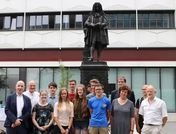 Siegerteam der Leibniz-Matheolympiade vor der Leibniz-Statue auf dem Campus Augustusplatz der Universität Leipzig