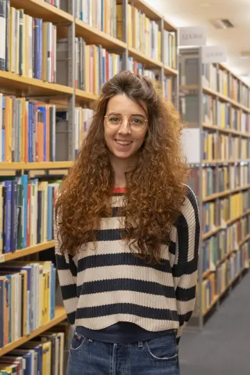 Portrait of Lisa Seccia in front of bookshelves