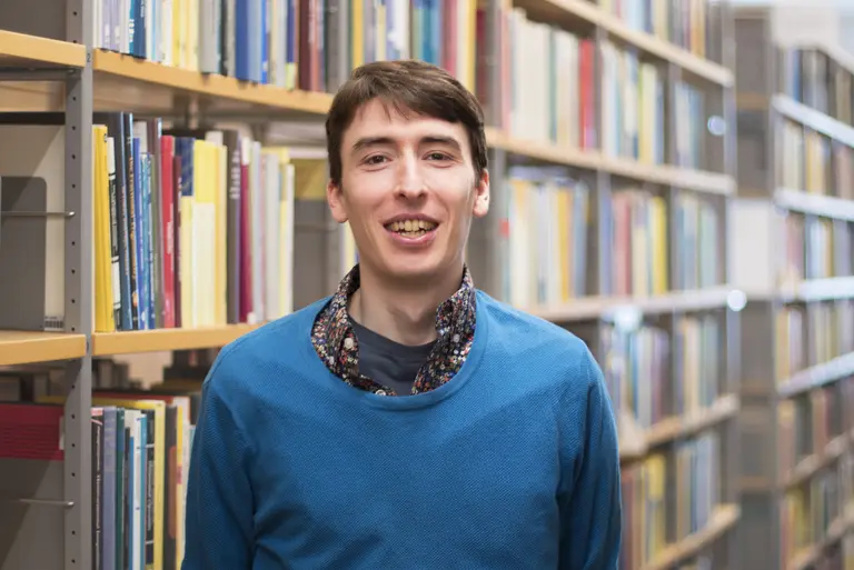 Portrait of Sam G. Krupa in front of bookshelves