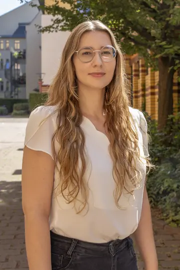 Portrait of Renata Possobon in front of bookshelves