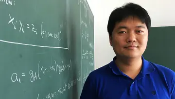 Yue Ren next to a blackboard with mathematical formulas