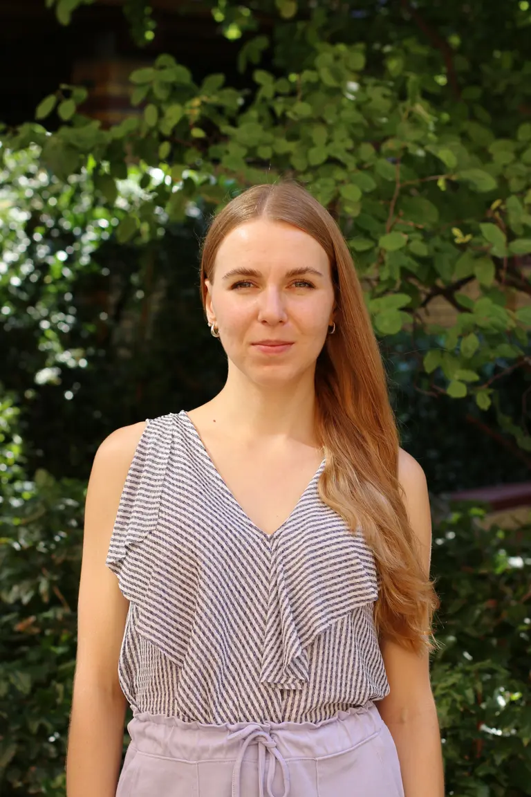 Portrait of Irina Bobrova outside in front of green plants