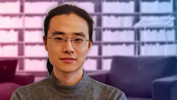 Portrait of Shuhan Jiang with bookshelves in the background