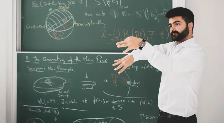 Renan Assimos Martins is giving a lecture in front of a blackboard