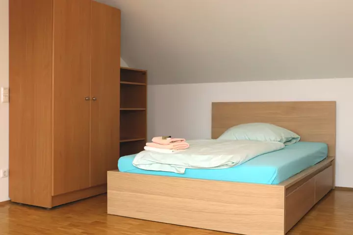 Schlafzimmer mit Schrank und Bett