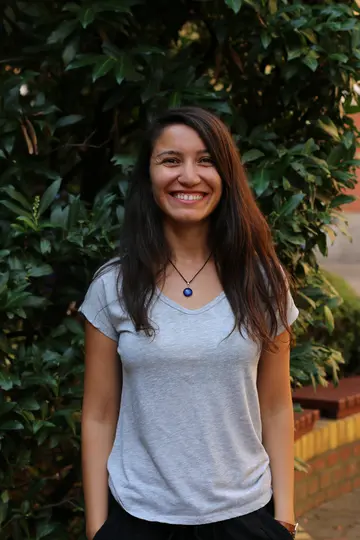 Portrait of Sefika Kuzgun outside in front of green plants