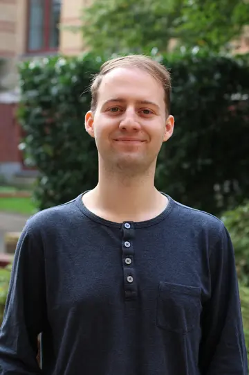 Portrait of Anton Ullrich outside in front of green plants
