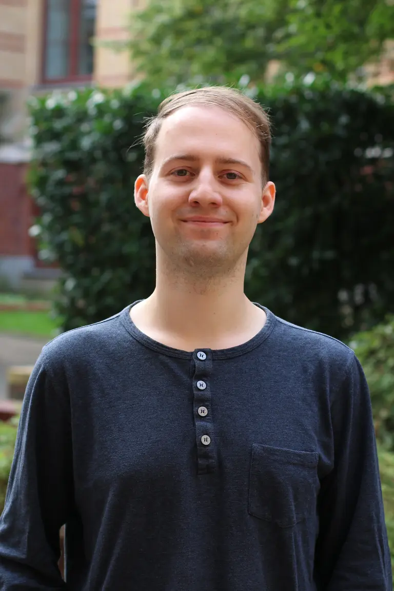 Portrait of Anton Ullrich outside in front of green plants