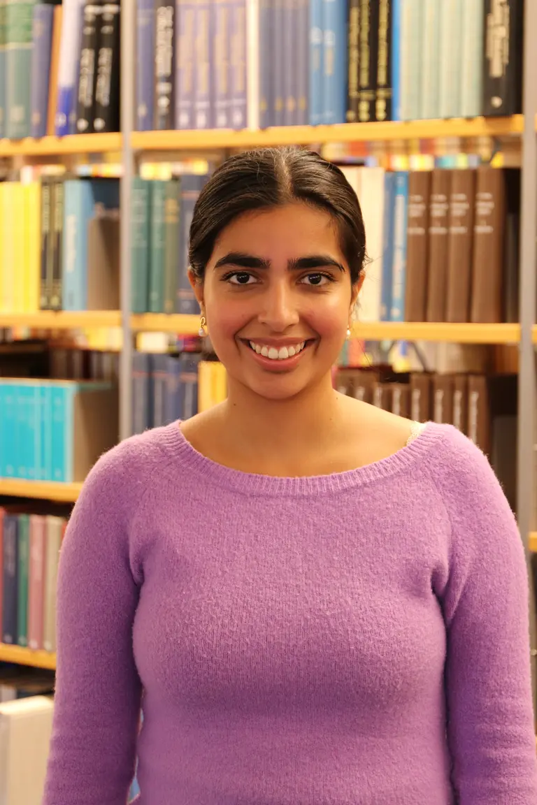 Portrait of Niharika Paul in front of bookshelves