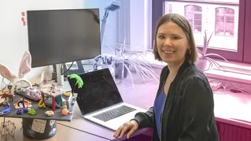 Marie-Charlotte Brandenburg smiling with her decorated PhD hat