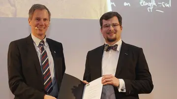 Tobias Ried at the award ceremony for the KIT Doctoral Award, holding a certificate in his hands