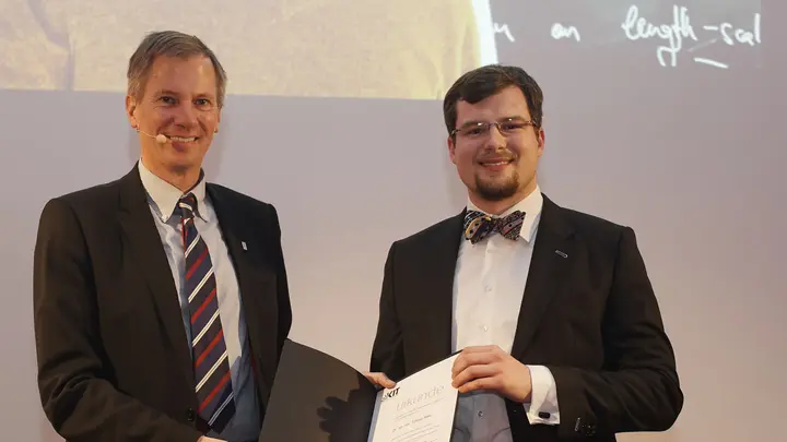 Tobias Ried bei der Preisverleihung, hält eine Urkunde in Händen